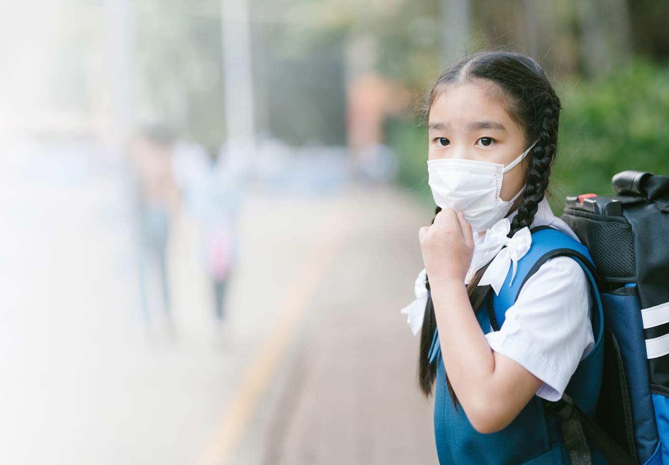 Jeune écolière portant un masque contre la pollution