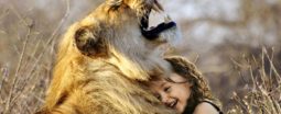 Enfant câlinant une lionne