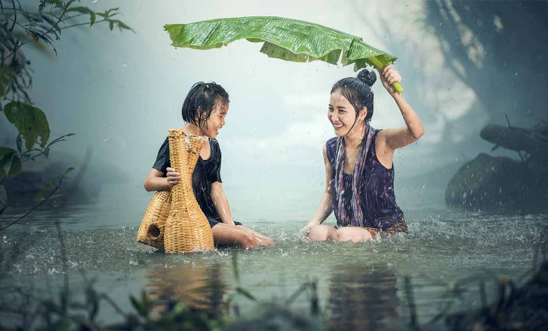 Femme et enfant souriants sous la pluie