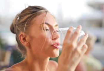 Femme buvant un verre d'eau pure et vivante