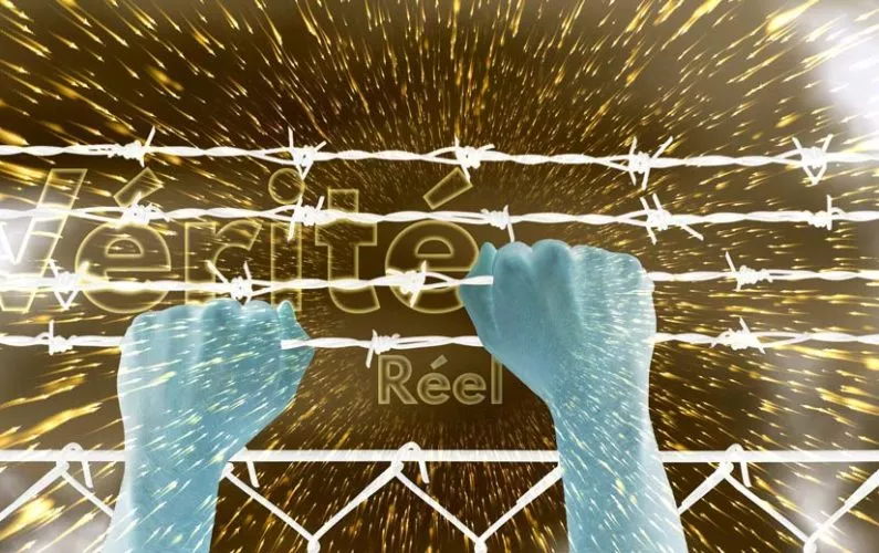 Mains prisonnières sur des barbelés avec en fond les mots réel et vérité